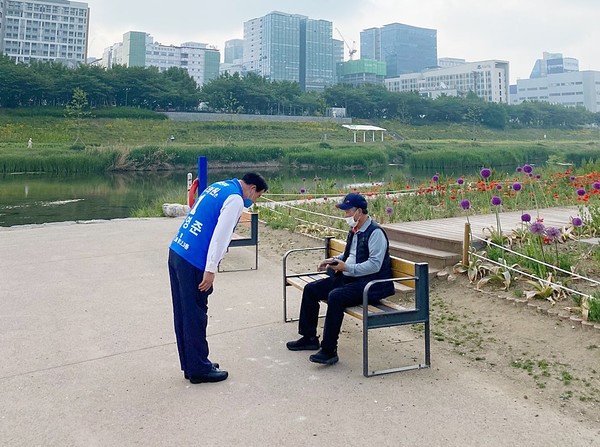 김영준 더불어민주당 경기도의원(광명1) 후보가 안양천에서 만난 한 시민에게 정중하게 인사를 하는 모습.